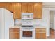 The kitchen features wood cabinets, white appliances, and countertops with white tile backsplash at 219 Prominent Loop, Mcdonough, GA 30253