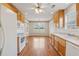 Bright eat-in kitchen features wood cabinets, appliances, and wood floors with large windows for natural light at 219 Prominent Loop, Mcdonough, GA 30253