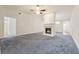 Spacious living room with a fireplace, neutral color scheme, and plush gray carpeting, offering a cozy ambiance at 219 Prominent Loop, Mcdonough, GA 30253