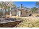 Exterior side view of a house with a terraced retaining wall, steps, and mature trees at 3141 Buck Branch Sw Rd, Conyers, GA 30094