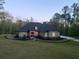 Elegant home with a dark roof and a circular driveway, nestled among mature trees at 3141 Buck Branch Sw Rd, Conyers, GA 30094