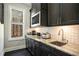 Charming kitchenette features black cabinets, granite countertops, stainless steel appliances, and a window with wooded view at 3141 Buck Branch Sw Rd, Conyers, GA 30094