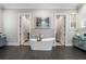Bright main bathroom with a modern soaking tub between two closet entrances and and vanities at 3141 Buck Branch Sw Rd, Conyers, GA 30094