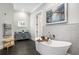 Luxurious main bathroom features a modern soaking tub, vanity with stylish lighting, and decorative wall texture at 3141 Buck Branch Sw Rd, Conyers, GA 30094