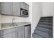 Compact kitchenette features gray cabinets, granite countertops, stainless steel appliances, and stairs at 2000 Ocean Nw Dr, Atlanta, GA 30318