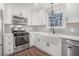 Modern kitchen featuring stainless steel appliances, white cabinets, and a farmhouse sink at 448 Buckingham Dr, Marietta, GA 30066