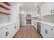 Stylish kitchen with stainless steel appliances, white cabinetry, and floating wood shelves at 448 Buckingham Dr, Marietta, GA 30066