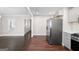 A bright kitchen featuring stainless steel appliances, white cabinetry, and hardwood flooring at 2506 Maple St, East Point, GA 30344