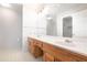 Bathroom featuring double sinks, white countertops, wood cabinets, large mirror, and tile floors at 2533 Briers North Dr, Atlanta, GA 30360