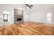 Spacious living room featuring hardwood floors, stone fireplace, ceiling fan, and large windows for natural light at 2533 Briers North Dr, Atlanta, GA 30360