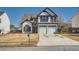 Charming two-story home with a two-car garage and manicured front yard on a sunny day at 3291 Quincey Xing, Conyers, GA 30013