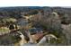 Stunning aerial view of a suburban home with mature trees, lush greenery, and a tranquil lake at 1460 Lakemist Ct, Roswell, GA 30075