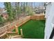 Elevated view of a fenced backyard with artificial turf, trees, and other homes at 1460 Lakemist Ct, Roswell, GA 30075