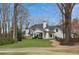 White-painted brick home with a well manicured lawn and lush, mature trees, providing privacy and curb appeal at 1460 Lakemist Ct, Roswell, GA 30075