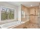 Luxurious bathroom featuring a soaking tub with a large window and a glass-enclosed shower with bench at 1460 Lakemist Ct, Roswell, GA 30075
