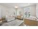 Bright Bedroom featuring two cribs, neutral decor, and ample natural light from shuttered windows at 1460 Lakemist Ct, Roswell, GA 30075