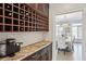 Butler's pantry with wine rack, granite counters, and a view of a dining area, perfect for serving and entertaining at 1460 Lakemist Ct, Roswell, GA 30075