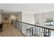 Second floor hallway featuring wood floors, metal railings, modern chandelier and plenty of natural light at 1460 Lakemist Ct, Roswell, GA 30075