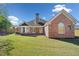 Well-maintained backyard with brick exterior, lush green lawn, and privacy fence at 2528 Picket Fence Ln, Snellville, GA 30078