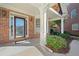 Inviting front porch with brick siding, decorative door, and manicured landscaping at 2528 Picket Fence Ln, Snellville, GA 30078