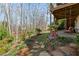 Charming backyard featuring a cozy patio swing, landscaped garden beds and tree lined backdrop at 1760 Clayton Cir, Cumming, GA 30040