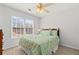 Bright bedroom with a floral comforter, ceiling fan, and large window that provides plenty of natural light at 1760 Clayton Cir, Cumming, GA 30040