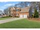 Charming two-story brick home with an attached two-car garage and a lush green lawn at 1760 Clayton Cir, Cumming, GA 30040