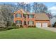 Charming two-story red brick home featuring a manicured lawn, black shutters and a two car garage at 1760 Clayton Cir, Cumming, GA 30040