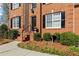 Close up of a brick two-story house with lush landscaping and a walkway leading to the front door at 1760 Clayton Cir, Cumming, GA 30040