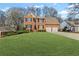 Charming two-story red brick home featuring a manicured lawn, black shutters and a two car garage at 1760 Clayton Cir, Cumming, GA 30040