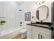 Well-lit bathroom featuring subway tile shower and vanity with black granite countertop at 2788 Browns Mill Se Rd, Atlanta, GA 30354