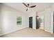 Bedroom with ceiling fan and large window, complemented by dark trim around doors and baseboards at 2788 Browns Mill Se Rd, Atlanta, GA 30354