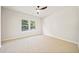 Bright bedroom with neutral carpet and paint featuring a modern ceiling fan and natural light at 2788 Browns Mill Se Rd, Atlanta, GA 30354