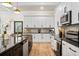 Modern kitchen with white cabinets, a black countertop island, and stainless steel appliances at 2788 Browns Mill Se Rd, Atlanta, GA 30354