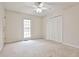 Bright bedroom features neutral carpet, a ceiling fan, and a large window at 573 Ripplewater Sw Dr, Marietta, GA 30064