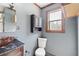 A well-lit bathroom featuring a toilet, vanity, mirror, and window at 6219 Holly Ann Se St, Acworth, GA 30102