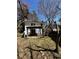 A home backyard featuring a white brick patio cover, green hillside, and a fenced perimeter at 6470 Wright Cir, Atlanta, GA 30328