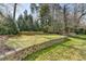 Beautifully maintained backyard featuring a stone retaining wall and mature trees at 1643 North Springs Dr, Dunwoody, GA 30338