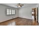 This bedroom features hardwood floors, one window with shutters and a ceiling fan at 1643 North Springs Dr, Dunwoody, GA 30338