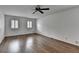 This bedroom features hardwood floors, two windows with shutters and a ceiling fan at 1643 North Springs Dr, Dunwoody, GA 30338