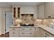 Kitchen boasts custom cabinetry, granite counters, and modern gas cooktop range at 1643 North Springs Dr, Dunwoody, GA 30338