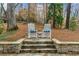 Relax in the inviting backyard retreat, complete with stone patio, rocking chairs, and serene natural surroundings at 4655 Jett Rd, Atlanta, GA 30327