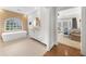 Bright bathroom featuring a modern tub, stone accent wall, and white vanity with natural light and an open view to the bedroom at 4655 Jett Rd, Atlanta, GA 30327