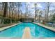 Beautiful pool with a diving board and plenty of seating for lounging outdoors with views of the surrounding nature at 4655 Jett Rd, Atlanta, GA 30327