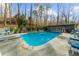 An in-ground backyard pool surrounded by stone with a lounge area with views of the backyard landscaping at 4655 Jett Rd, Atlanta, GA 30327