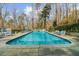 An in-ground backyard pool surrounded by stone with a large lounge area with views of the backyard landscaping at 4655 Jett Rd, Atlanta, GA 30327