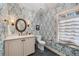 Charming powder room with stylish wallpaper, sleek fixtures and a black tile floor at 4655 Jett Rd, Atlanta, GA 30327