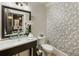 Stylish powder room featuring a vessel sink, elegant mirror, and unique patterned wallpaper at 5821 Clarion St # J8, Cumming, GA 30040