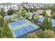 Aerial view of well-maintained tennis courts nestled among lush trees and greenery in the neighborhood at 5821 Clarion St # J8, Cumming, GA 30040