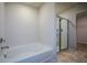 Bright bathroom featuring a soaking tub, glass shower, and tile flooring at 67 Highgrove Way, Dallas, GA 30157